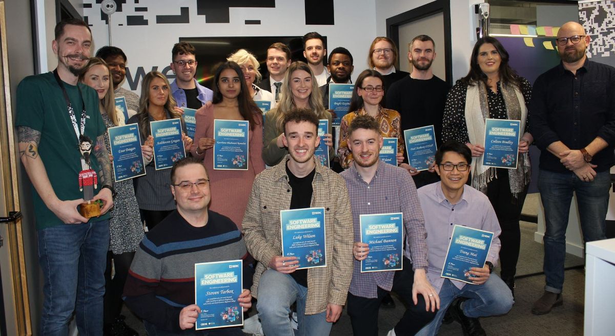 Group of 18 male and female students holding certificates with two tutors either side